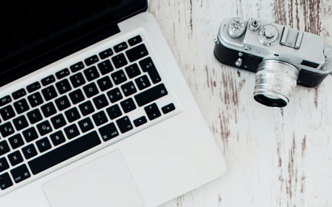 Laptop and camera on wood surface