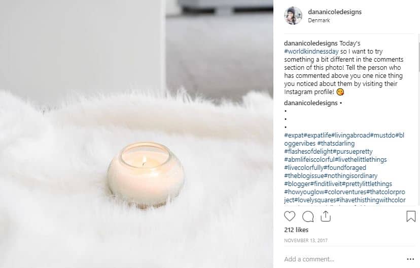 An instagram post of a candle on a white bed