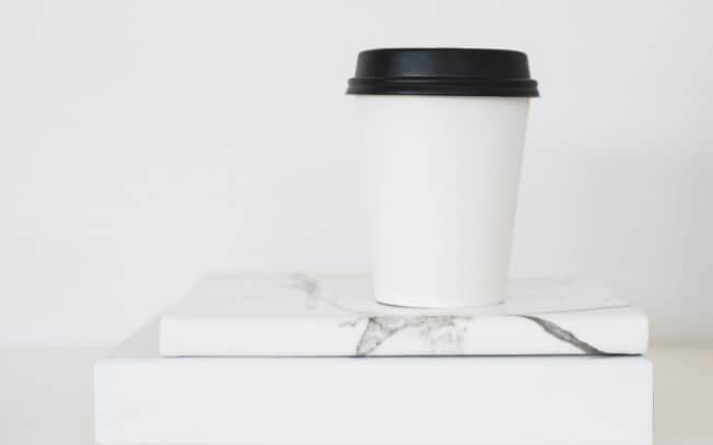 A paper cup of coffee on two books