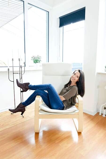 Brunette woman sitting in a chair smiling at the camera