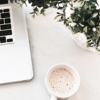 Laptop with coffee and flowers birds-eye view