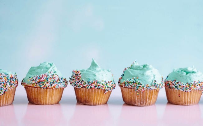 Cupcakes with blue icing on a pink table