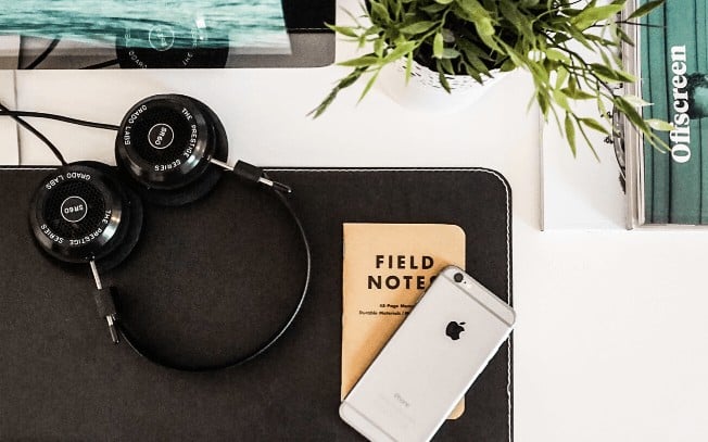 Phone, plant, notebook and headphones on a desk