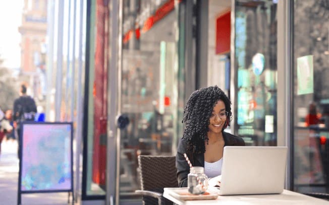 Woman sitting at a patio while working on her laptop