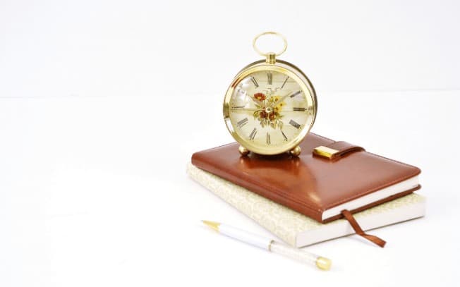A clock sitting on top of two books