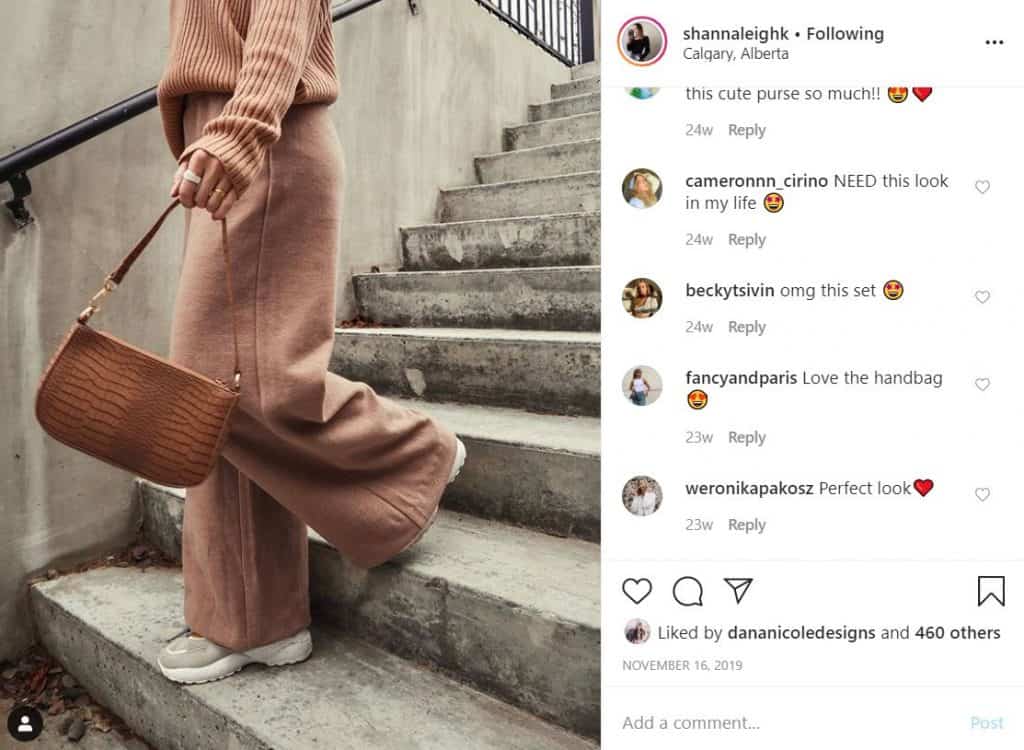 Screenshot of an Instagram image of a girl walking down the stairs holding a purse. The image is taken from the neck down.